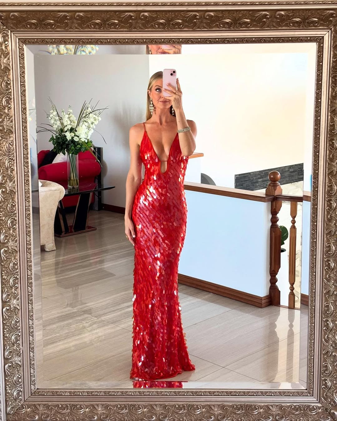 red sequin bodycon gown with plunging neckline reflected in ornate mirror
