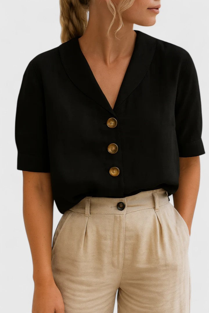 Black short-sleeve button-front blouse with shawl collar, paired with beige trousers