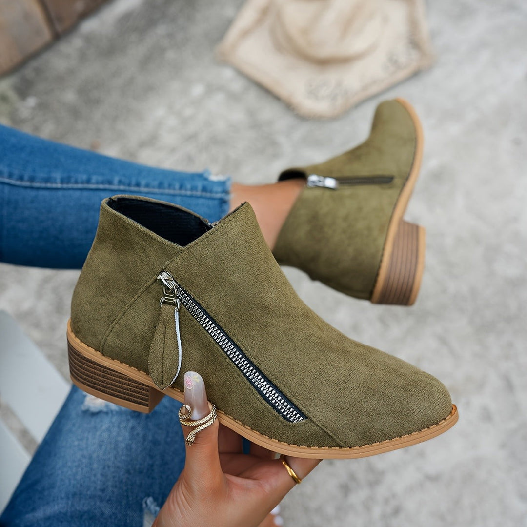 Olive green suede ankle boots with pointed toe worn on model