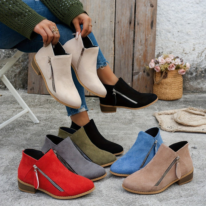 Assorted colour suede ankle boots displayed together with model