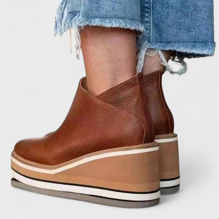 cognac leather wedge booties back view showing V-cut heel design