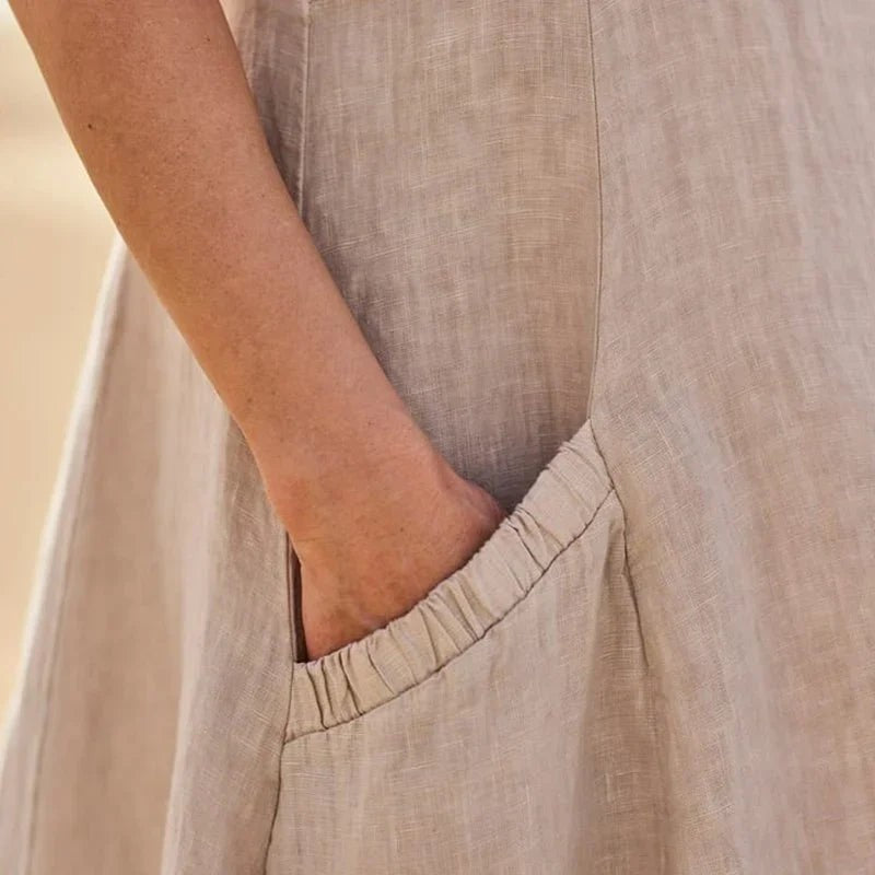 Close-up of hand in linen dress pocket showing textured fabric detail