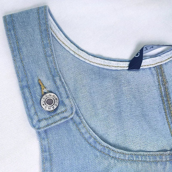 Detail of denim dress button strap with adjustable snap closure