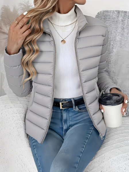 Light gray quilted puffer jacket worn with white sweater and skinny jeans