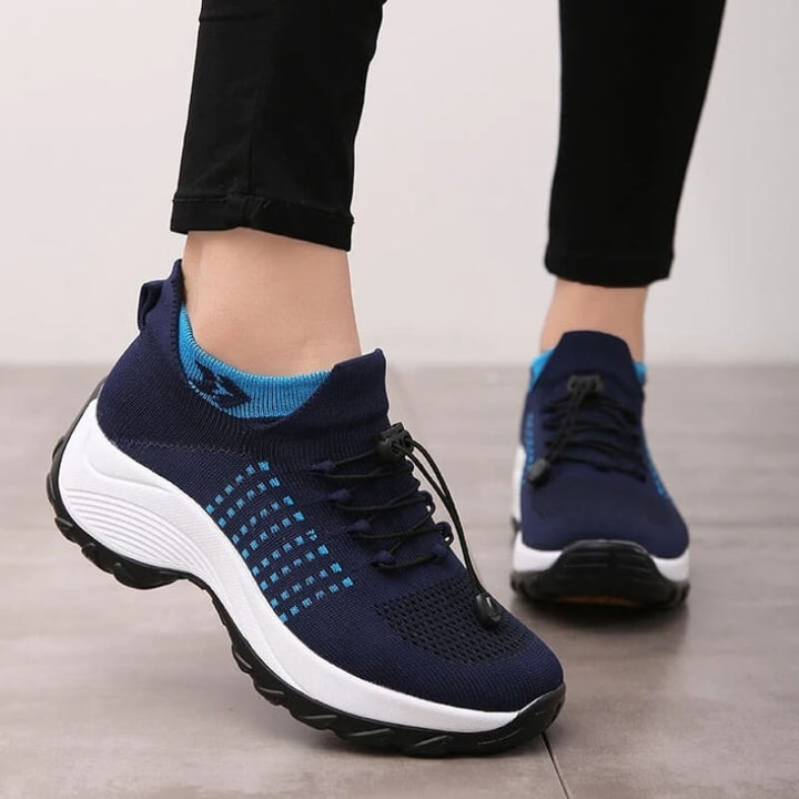 navy blue platform sneakers worn on feet with light blue trim