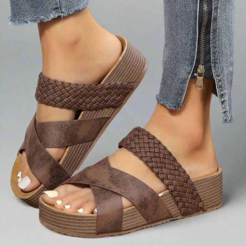 Brown woven platform sandals with crisscross straps worn with cropped jeans
