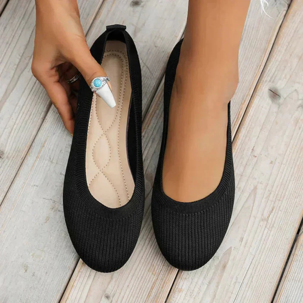 Black knit ballet flats with cushioned insole shown on bare feet