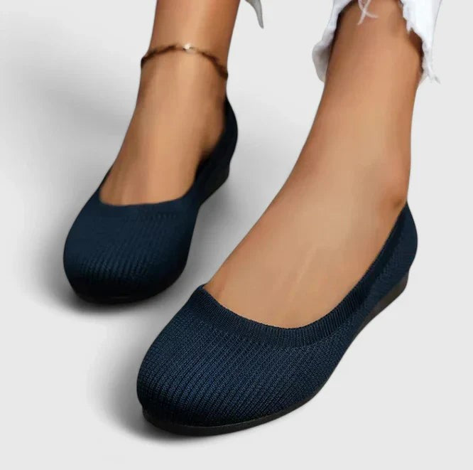 navy knit ballet flats worn on feet with round toe design