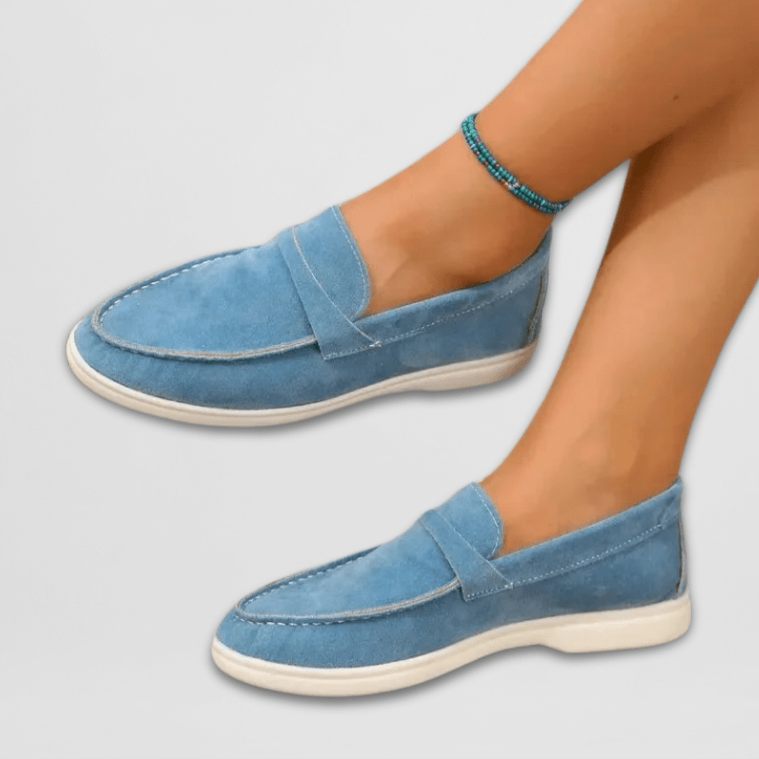 Side view of blue suede slip-on loafers with cream rubber outsole