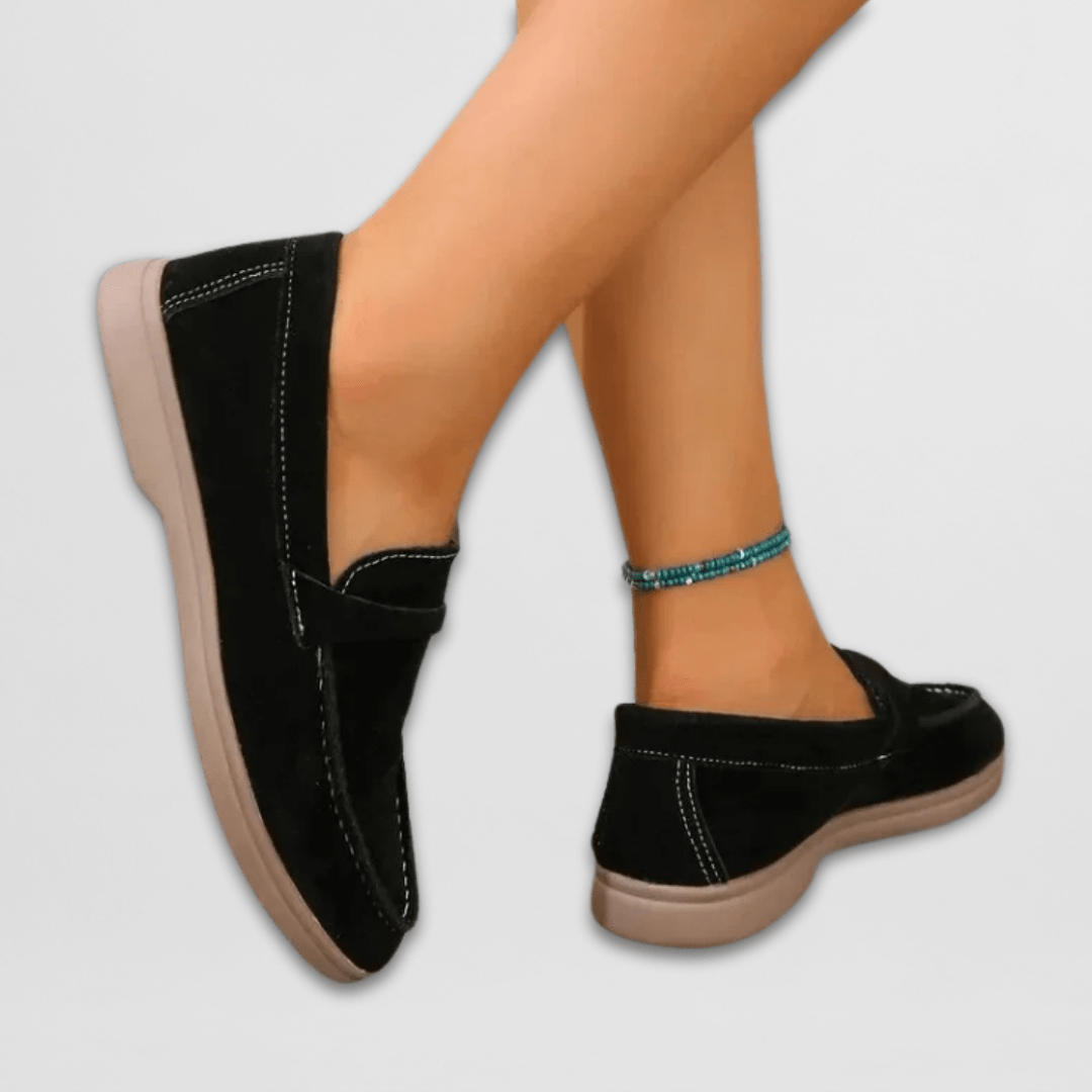 Back view of black suede loafers showing tan flat sole detail