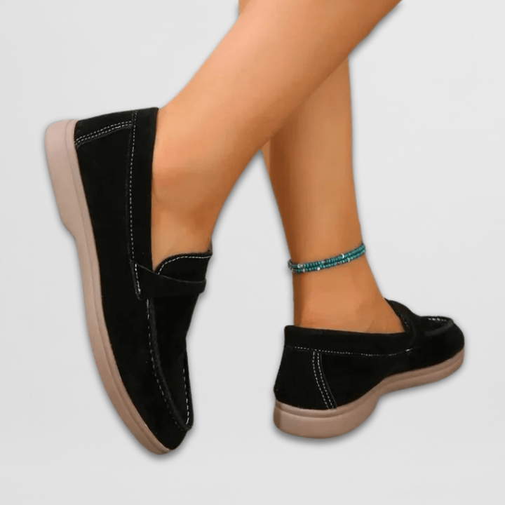 Back view of black suede loafers showing tan flat sole detail