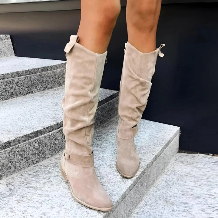 taupe suede slouch boots with side zipper worn on stone steps