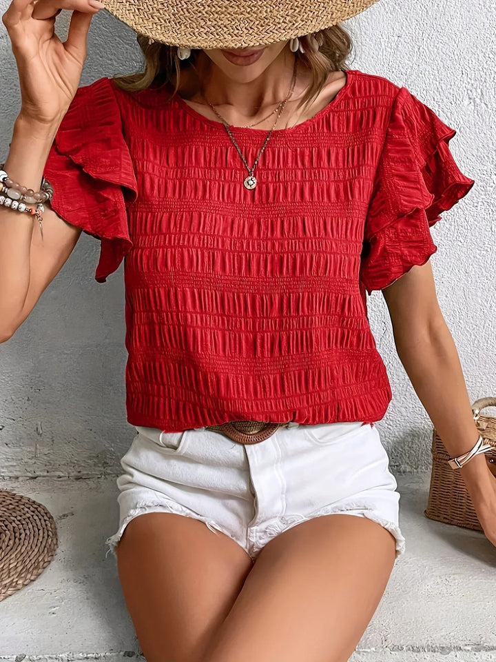 Red smocked blouse with ruffled sleeves paired with white denim shorts