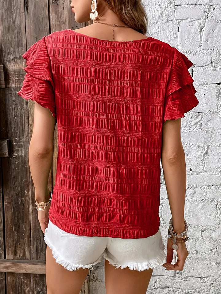 Back view of red textured blouse showing tiered ruffle sleeve detail