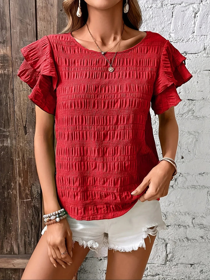 Red textured blouse with round neckline and ruffled cap sleeves