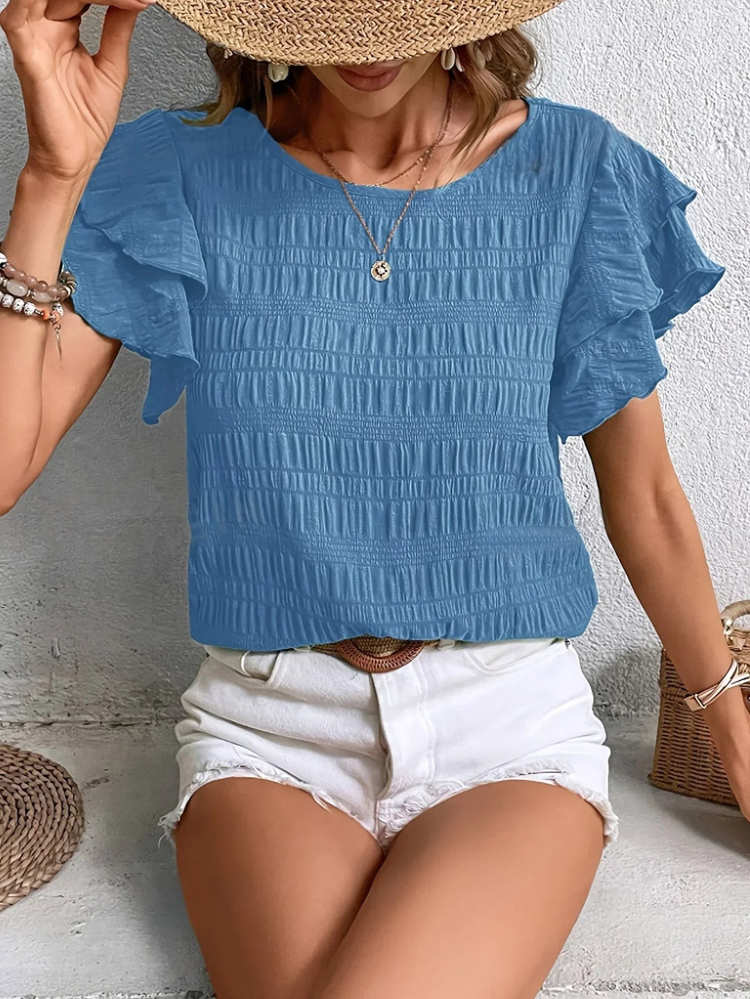 Blue smocked blouse with tiered ruffle sleeves and round neckline
