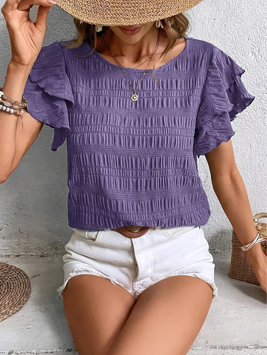 Purple textured top featuring ruffled short sleeves and smocked bodice