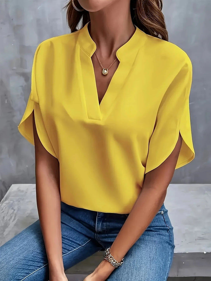 Yellow split-sleeve blouse with notched V-neck, paired with denim jeans