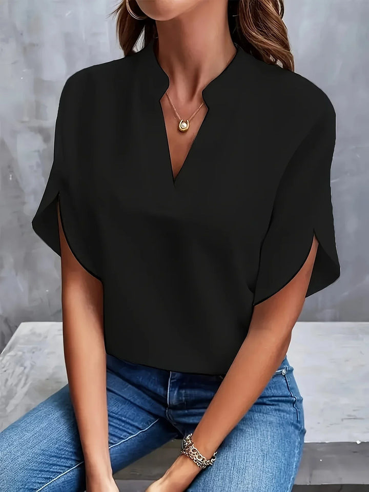 Black split-sleeve blouse showing notched V-neck and draped batwing sleeves
