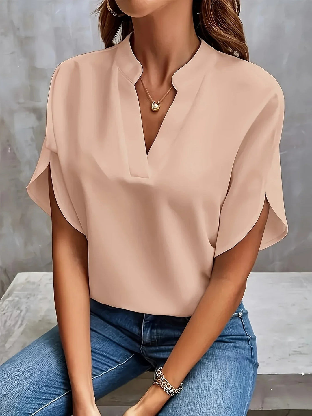 Beige split-sleeve blouse featuring notched V-neck and soft draped fabric