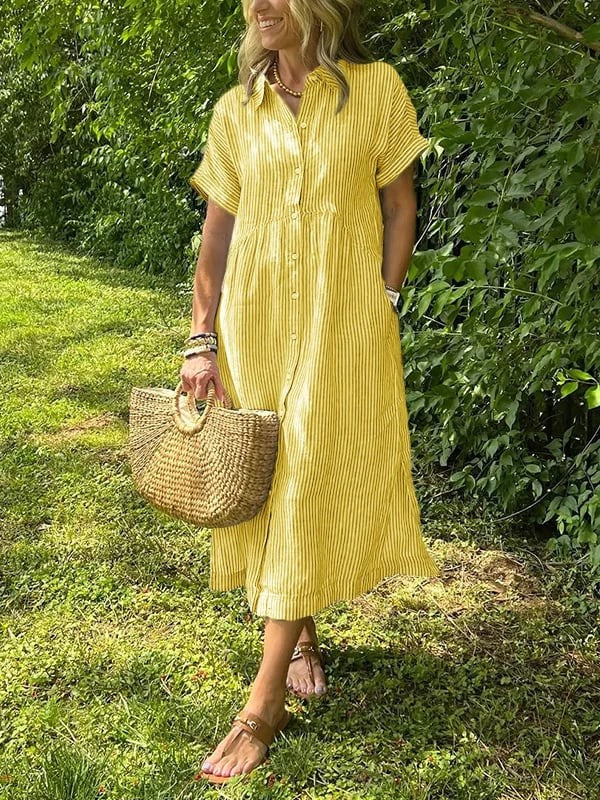 Yellow striped button-up shirt dress paired with woven straw handbag outdoors
