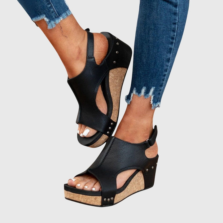 Black cork wedge sandals with ankle strap shown from side angle