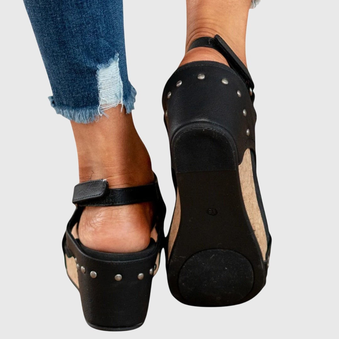 Black wedge sandal outsole with studded heel and cork platform base