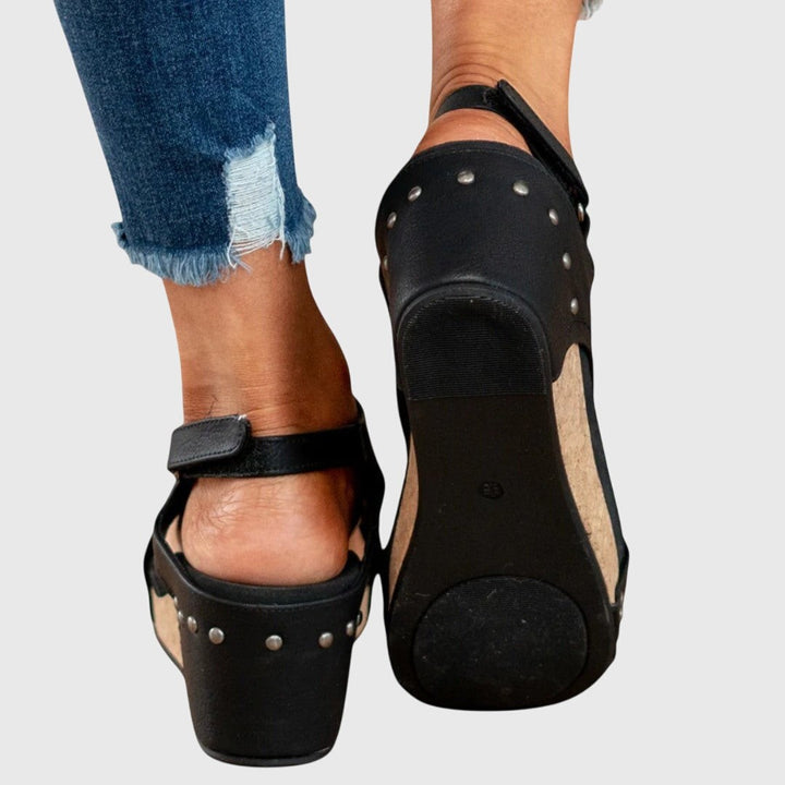 Black wedge sandal outsole with studded heel and cork platform base