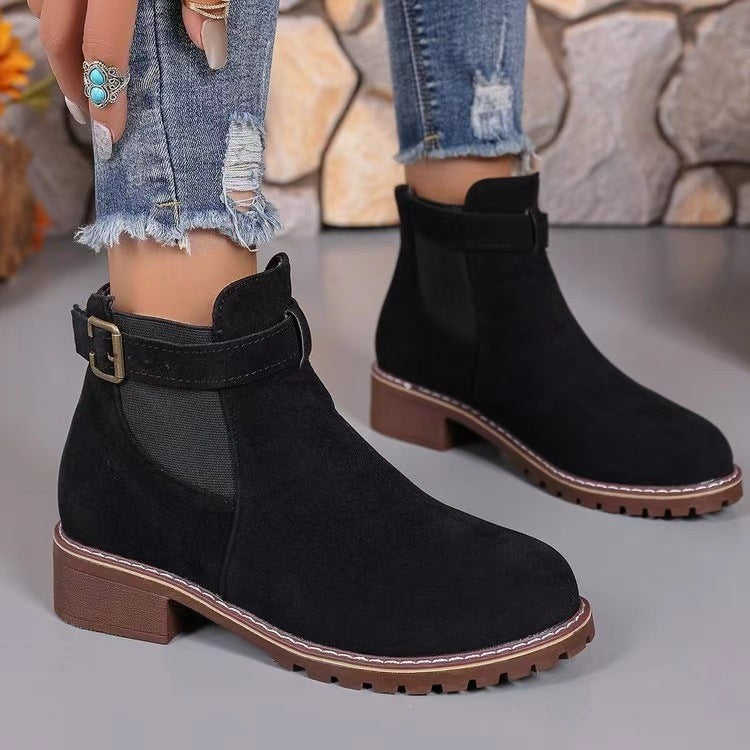 Black suede Chelsea boots with brass buckle strap and ridged sole
