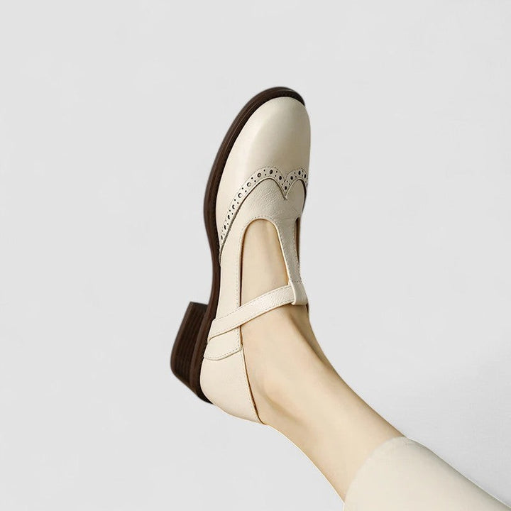 Cream leather Mary Jane shoe close-up showing wingtip brogue perforations