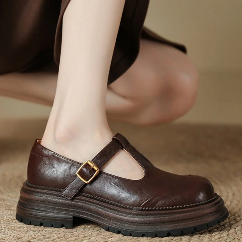 Side view of brown leather Mary Jane shoe with round toe and buckle strap
