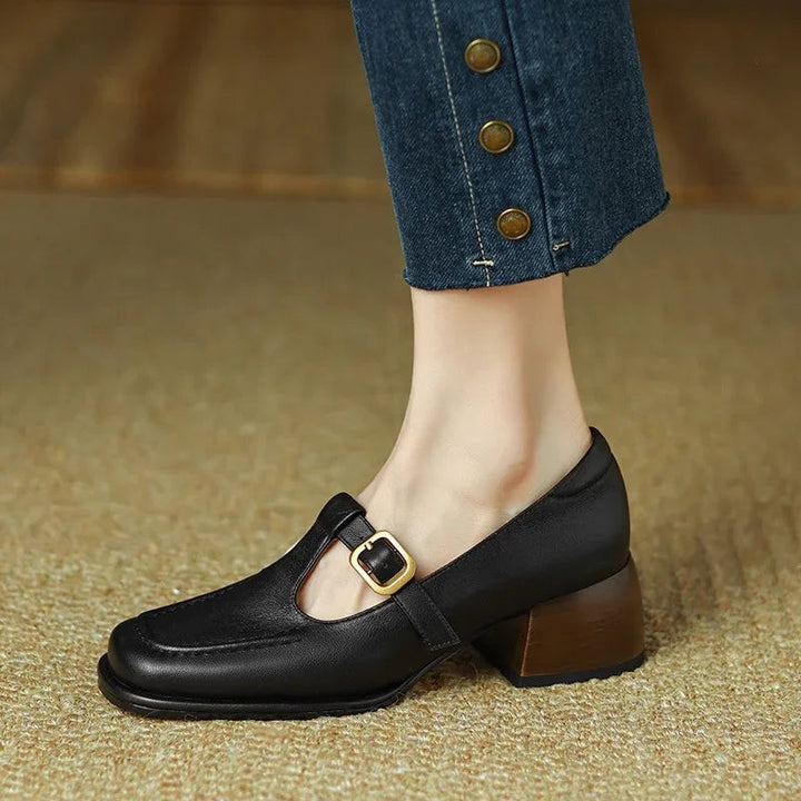 Black Mary Jane shoe showing gold buckle detail and low block heel