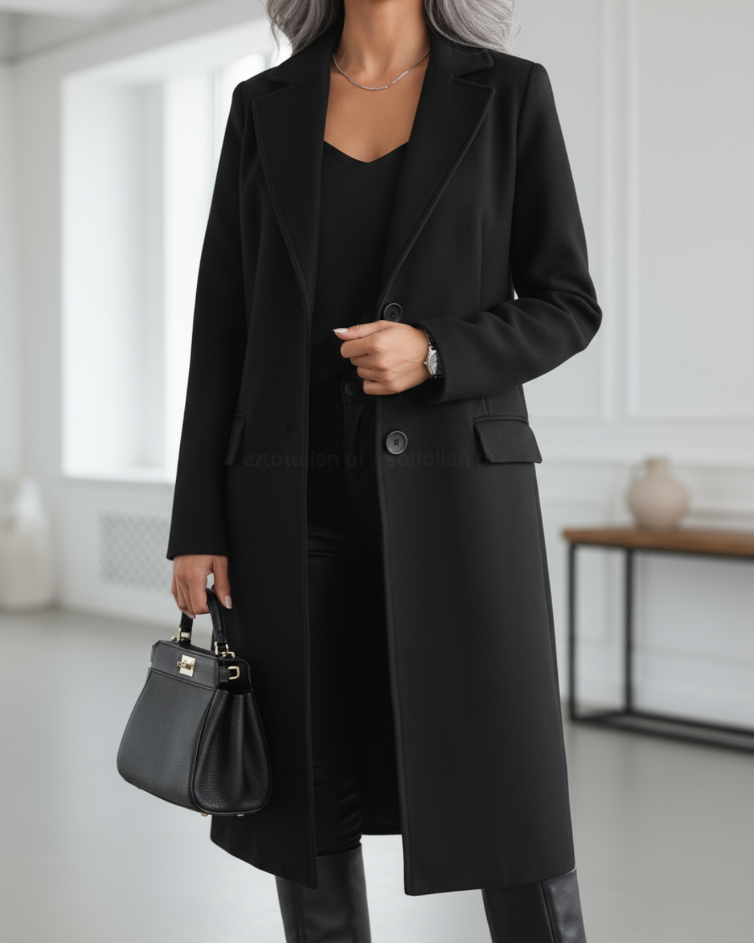 Black longline wool coat with notch lapel styled with matching handbag