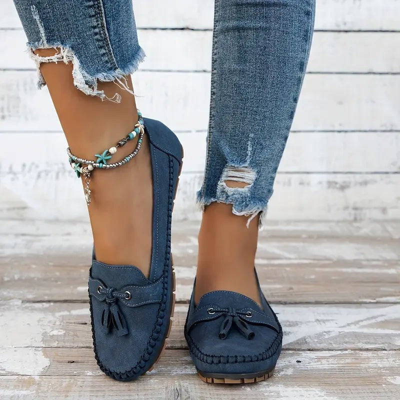 Navy suede loafers with whipstitch trim worn with distressed denim