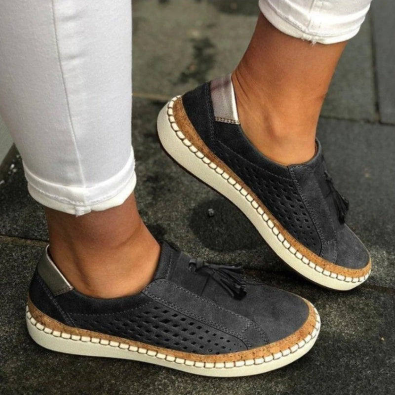 Charcoal gray suede slip-on sneakers with perforated sides and stitched cork sole