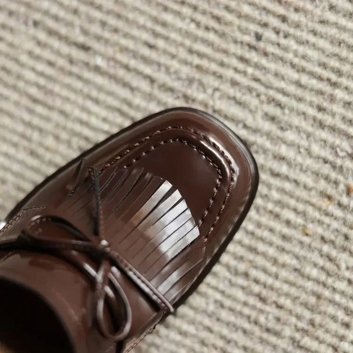 Top view of brown patent loafer toe with fringe tassel