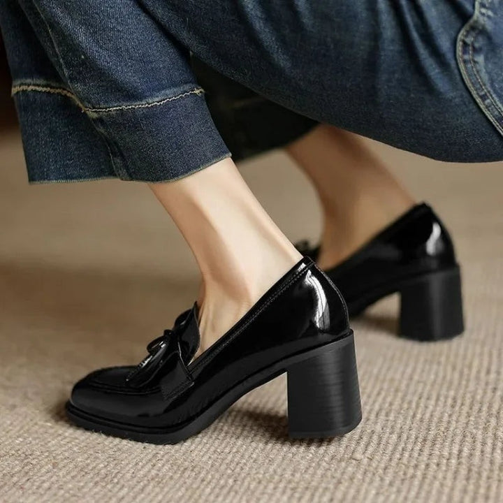 Close-up of black patent leather loafer heel with bow tassel