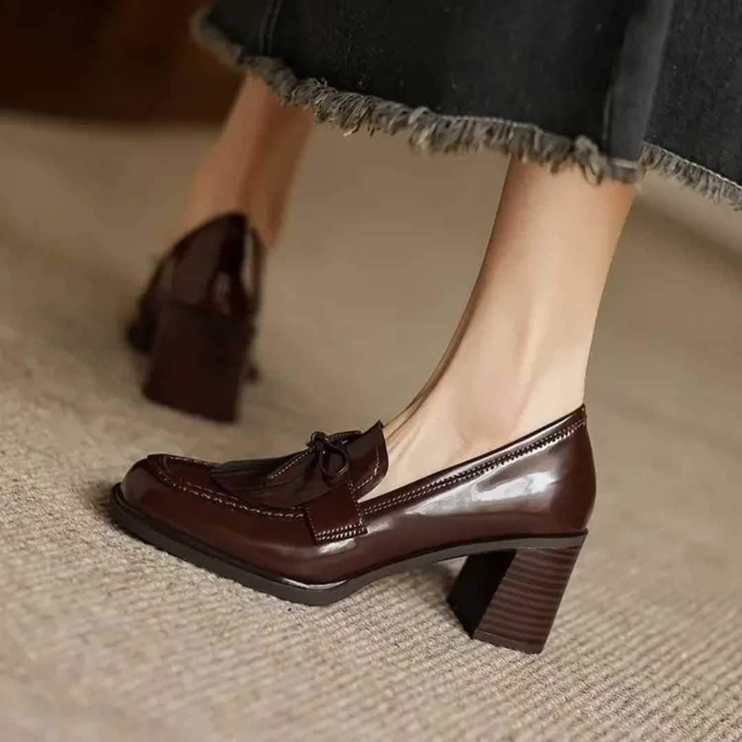 Side profile of brown patent tassel loafer with stacked heel