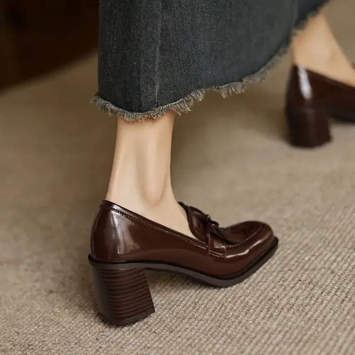 Back view of brown patent tassel loafer pumps with block heel