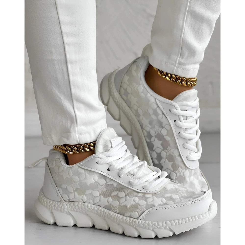Lace-up white chunky sneakers styled with cropped white pants and gold anklet