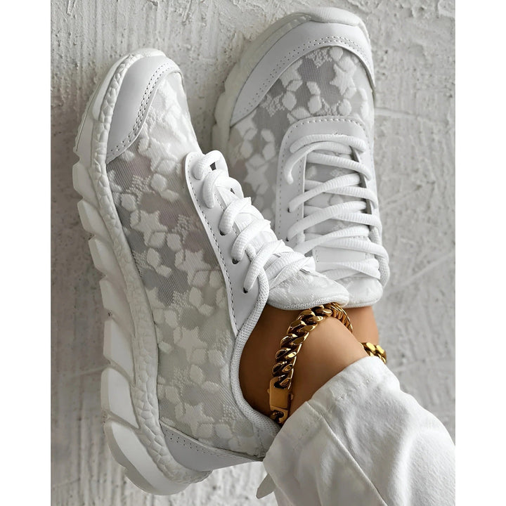 Close-up of white textured platform sneakers with thick tread and lace closure