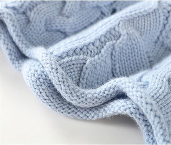 close-up of chunky cable knit texture on light blue sweater