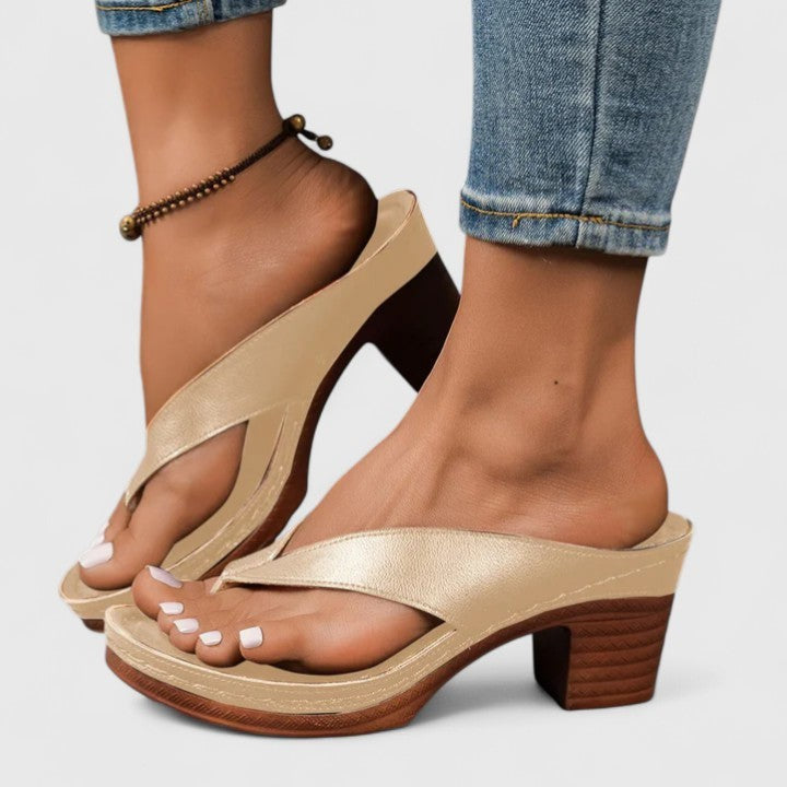 Gold leather thong sandals with platform sole and block heel, worn outdoors