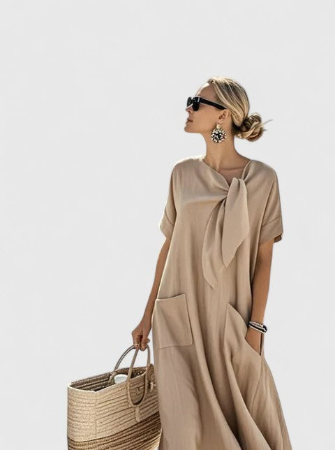 Taupe maxi dress with tie-neck detail, flowy silhouette and front pockets