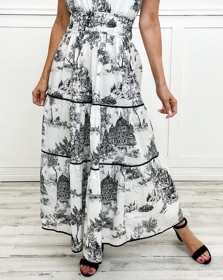 Close-up of black and white toile maxi dress showing tiered skirt and trim detail