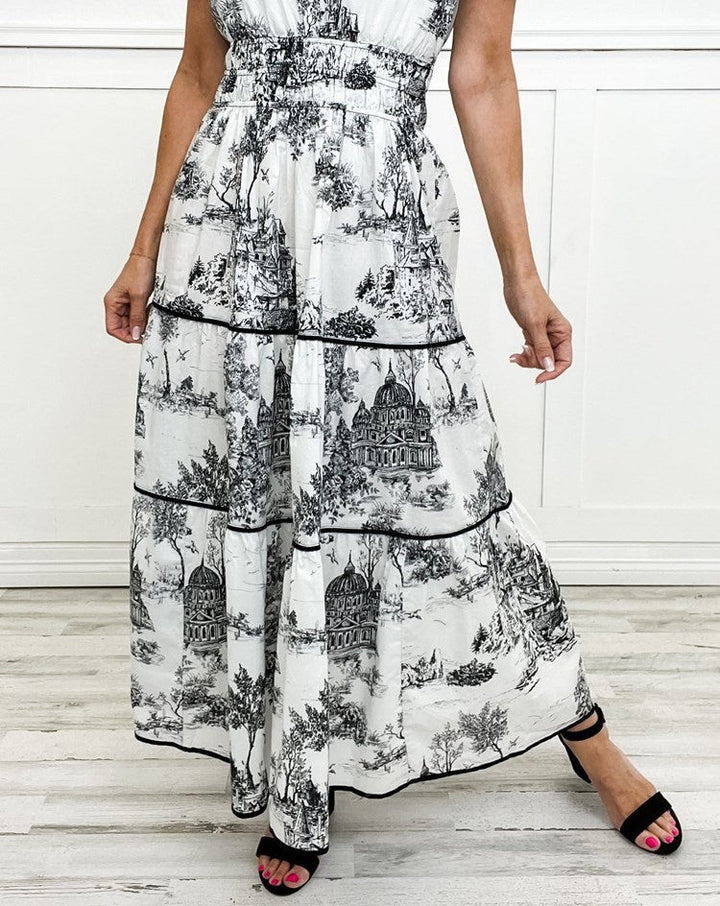 Close-up of black and white toile maxi dress showing tiered skirt and trim detail