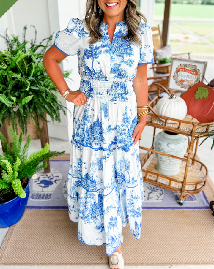 Blue and white toile print maxi dress with puff sleeves, standing on porch