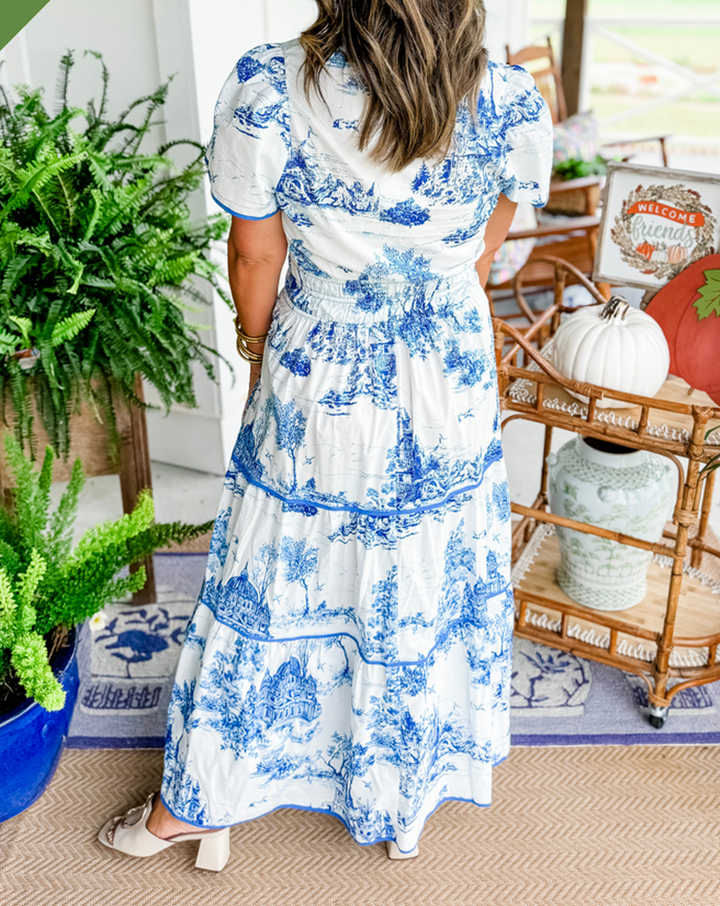 Back view of blue toile maxi dress highlighting tiered skirt and smocked waist