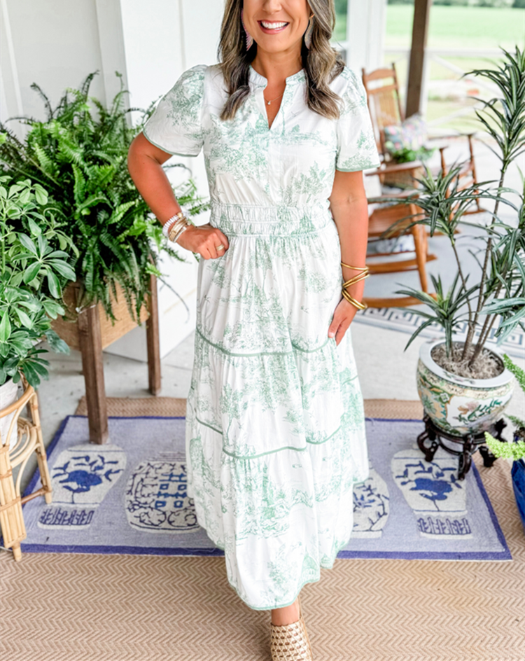 Green toile print maxi dress with tiered skirt, worn on outdoor porch