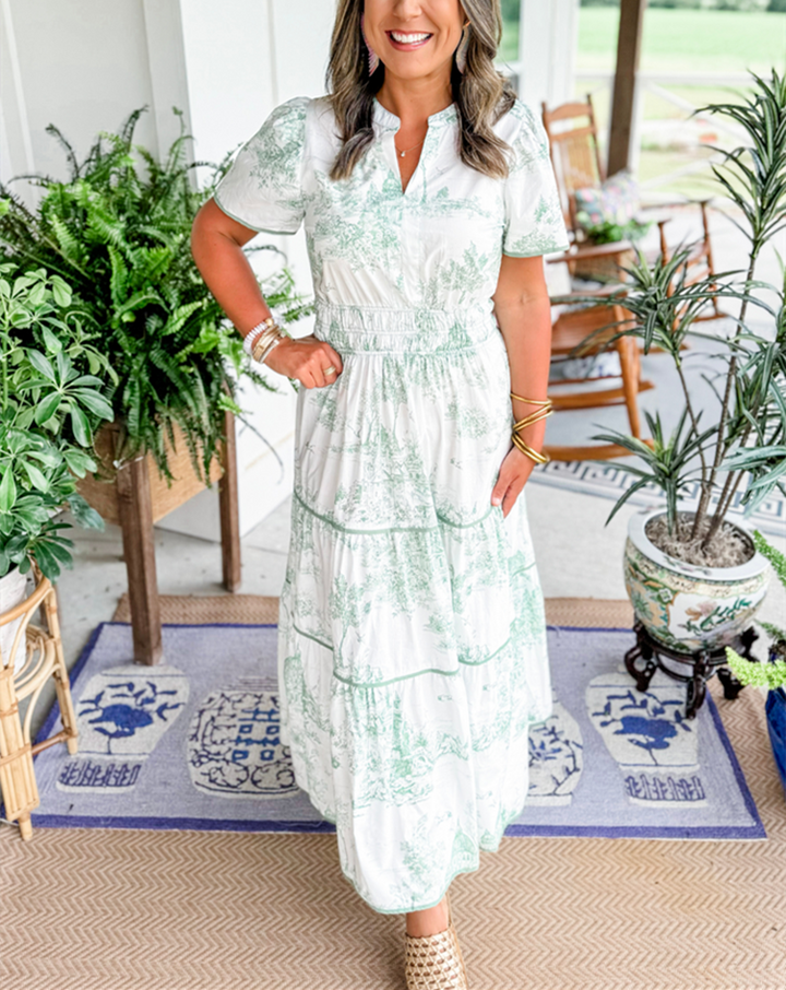 Green toile print maxi dress with tiered skirt, worn on outdoor porch